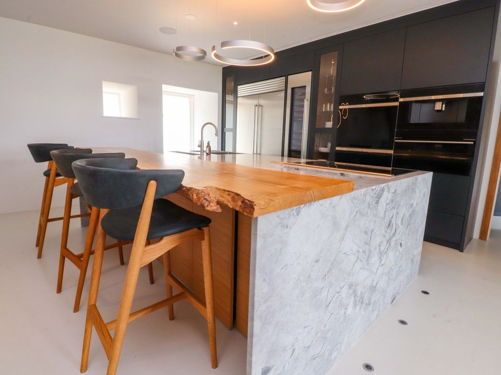 A kitchen with a bar island and stools at Carden Laithe Barn Threshfield