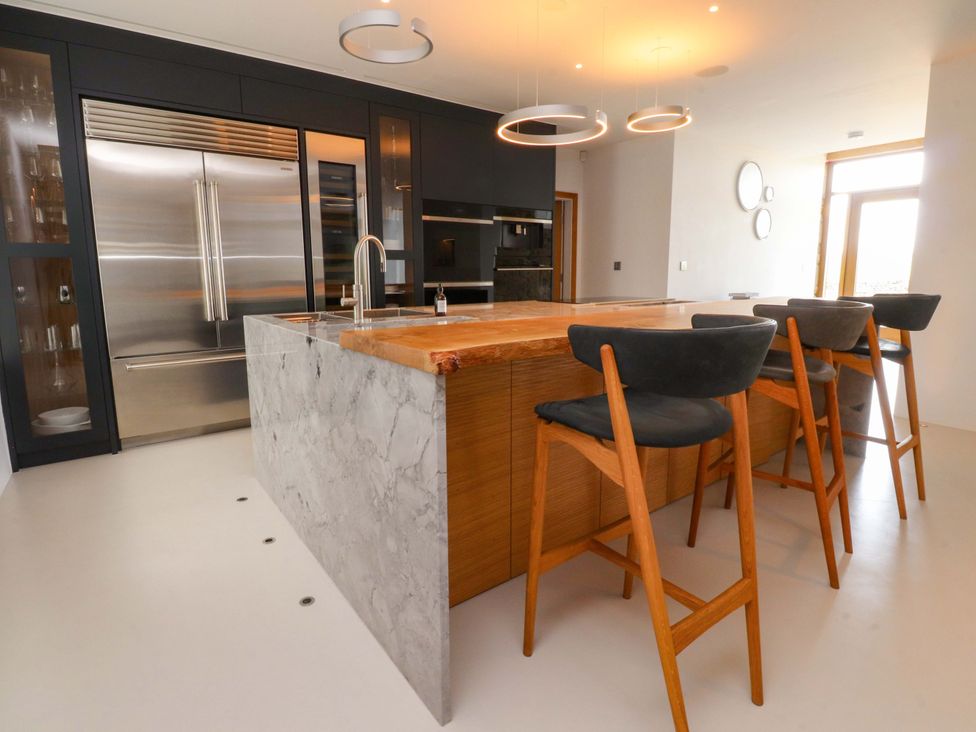 A kitchen with a large island and bar stools at Carden Laithe Barn in Threshfield