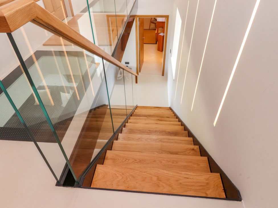 A staircase with wooden steps and a glass railing at Carden Laithe Barn Threshfield