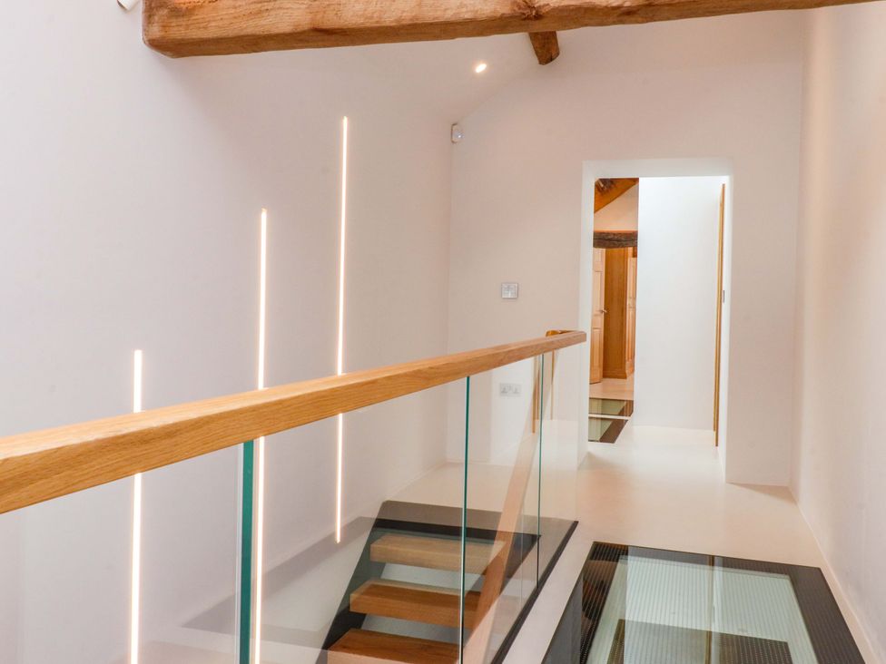 A hallway with a staircase and door at Carden Laithe Barn in Threshfield