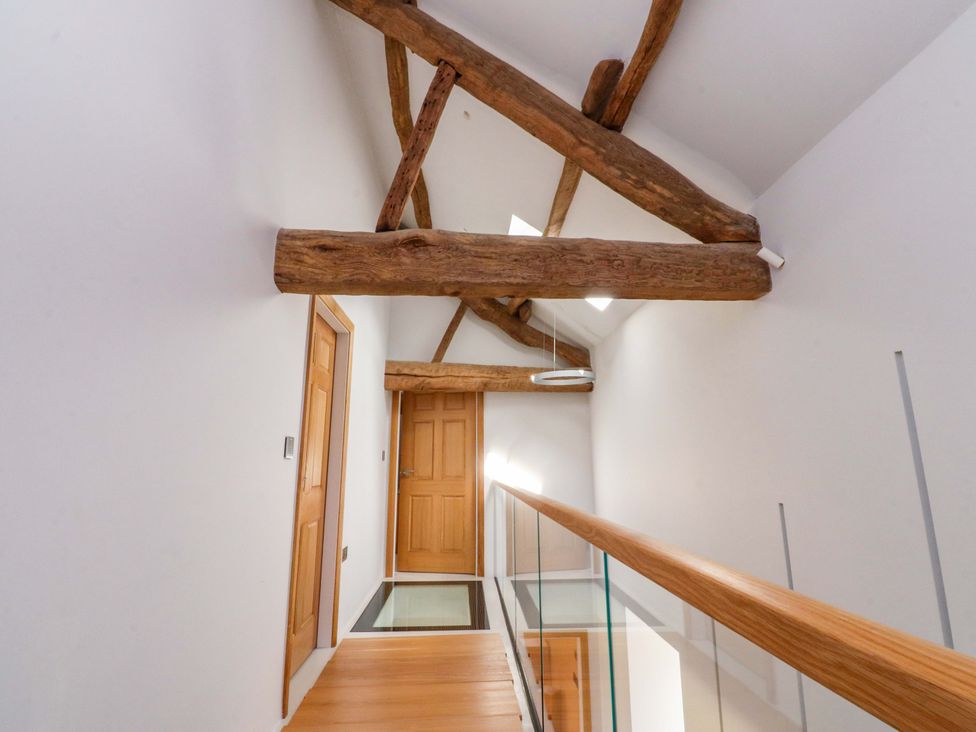 A hallway with wooden beams and doors at Carden Laithe Barn in Threshfield