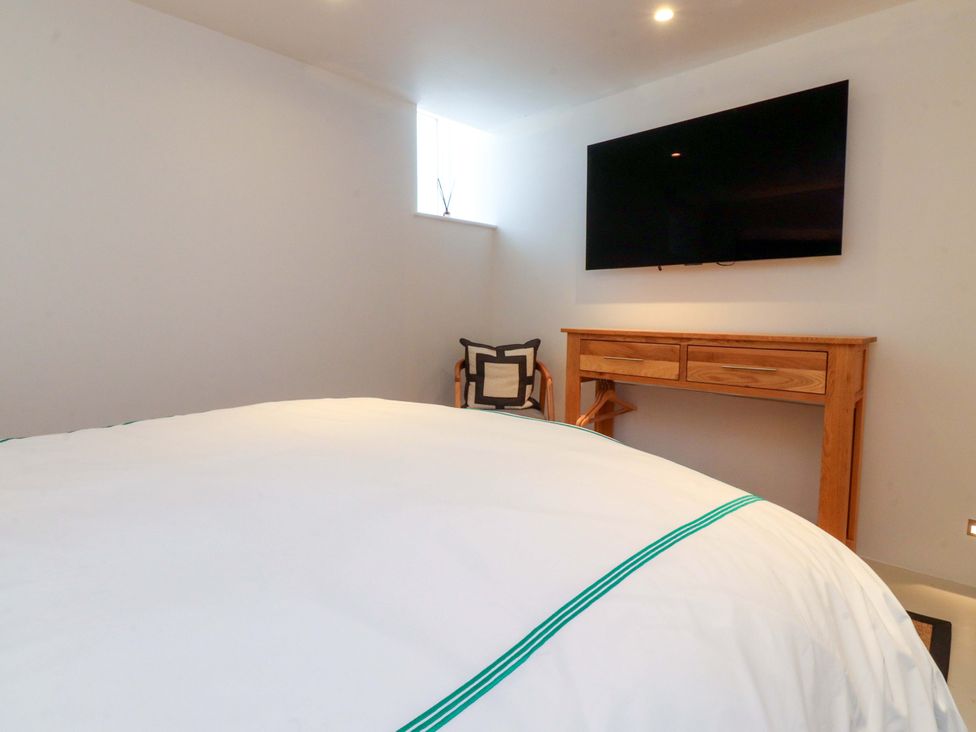 A bedroom featuring a bed, television, and table at Carden Laithe Barn in Threshfield