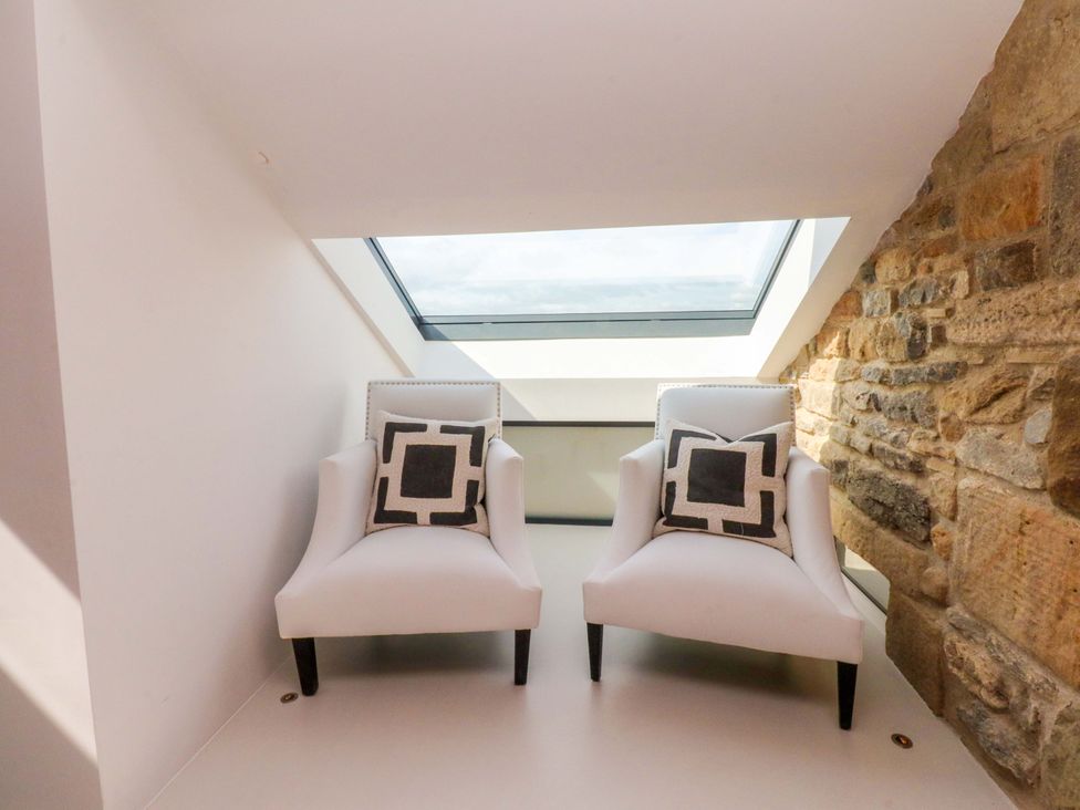A snug area with two chairs and a skylight at Carden Laithe Barn in Threshfield