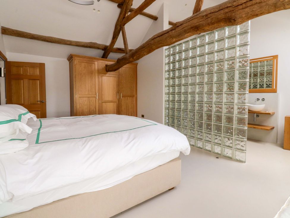 A bedroom with a bed and a glass block wall at Carden Laithe Barn in Threshfield