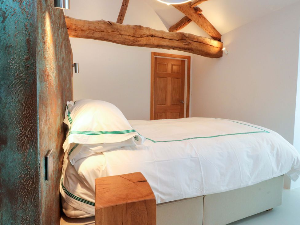 A bedroom with a bed and wooden beam at Carden Laithe Barn Threshfield