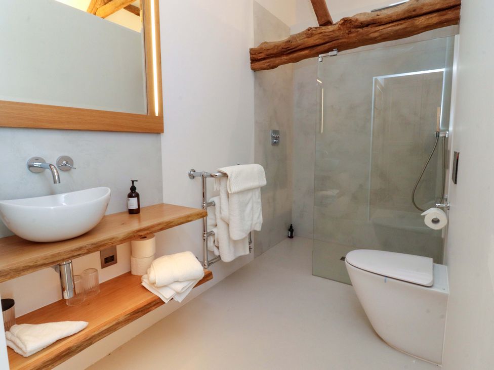 A bathroom with a sink, toilet, and shower at Carden Laithe Barn Threshfield