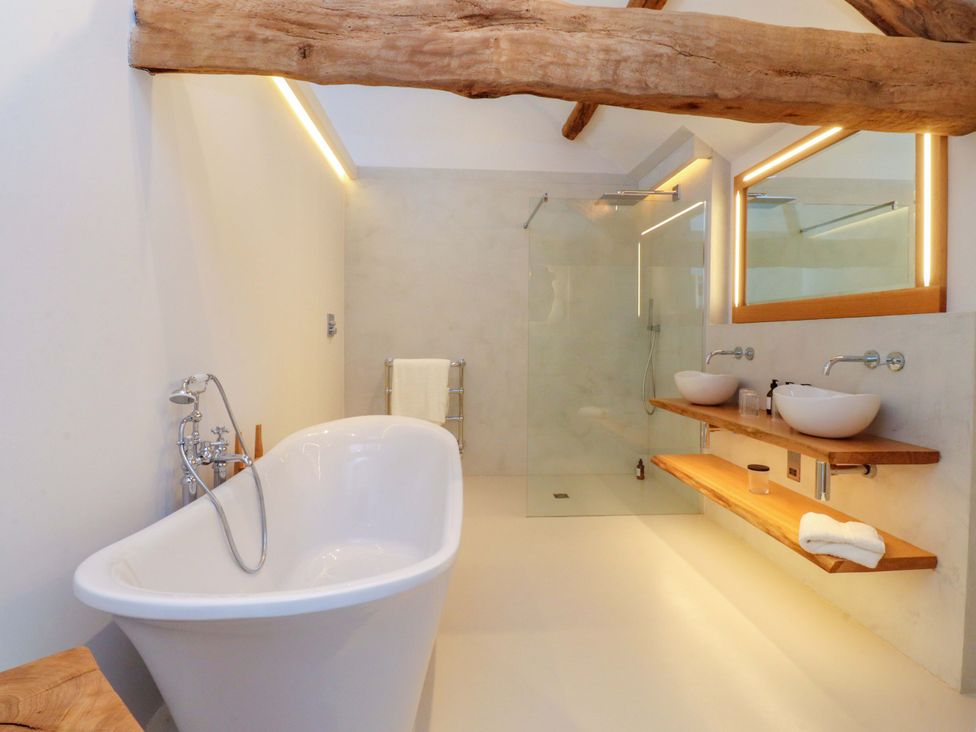 A bathroom with a bathtub and two sinks at Carden Laithe Barn Threshfield