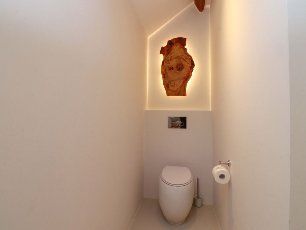 A bathroom with a toilet and wall art at Carden Laithe Barn Threshfield