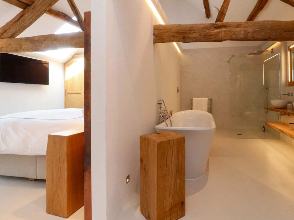A bathroom with a bathtub and shower area at Carden Laithe Barn in Threshfield