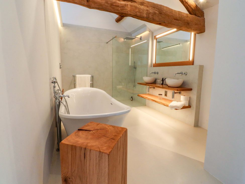 A bathroom with a bathtub and double sinks at Carden Laithe Barn Threshfield