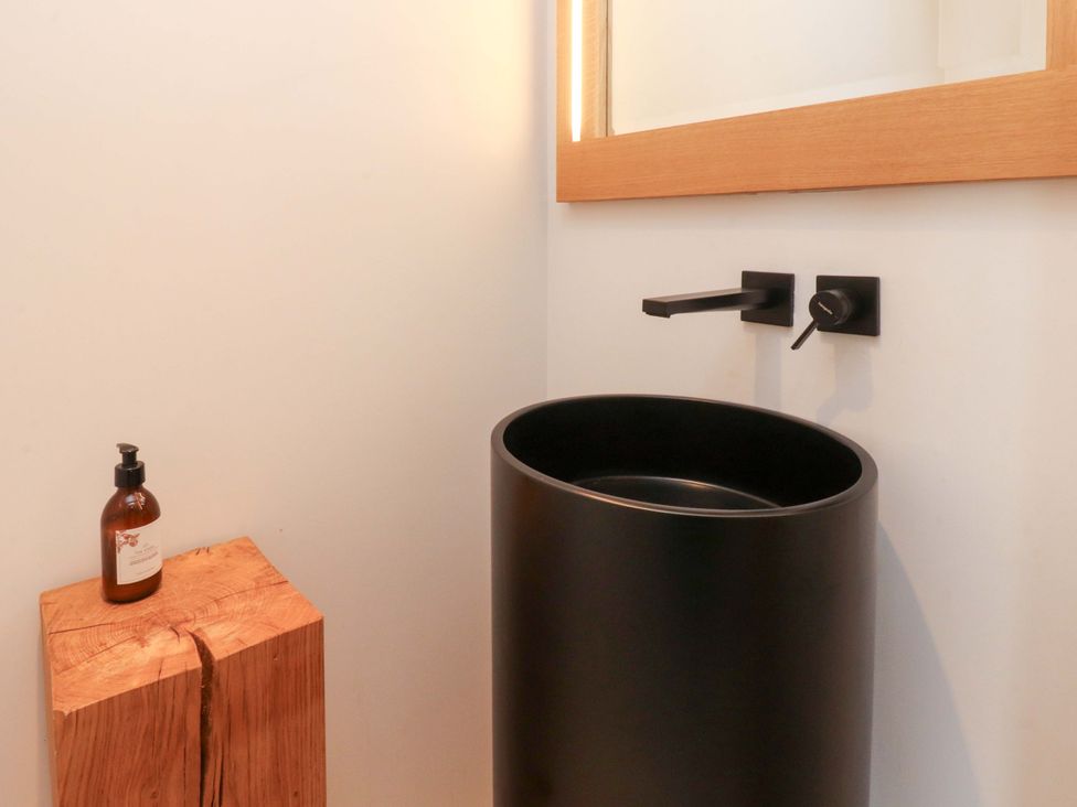 A bathroom with a circular sink and soap dispenser at Carden Laithe Barn Threshfield