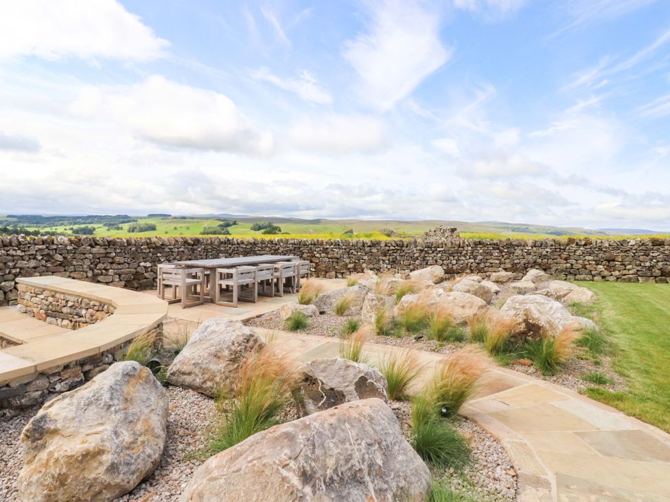 An outdoor garden with a stone wall and a seating area at Carden Laithe Barn Threshfield