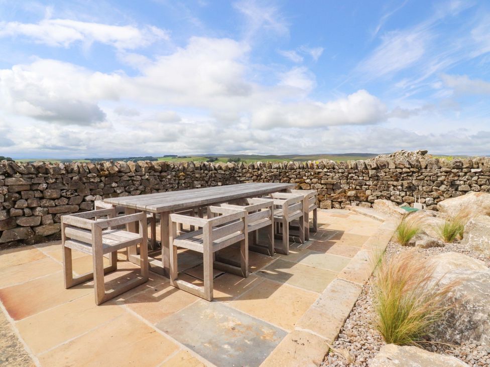 An outdoor seating area with a table and chairs at Carden Laithe Barn Threshfield