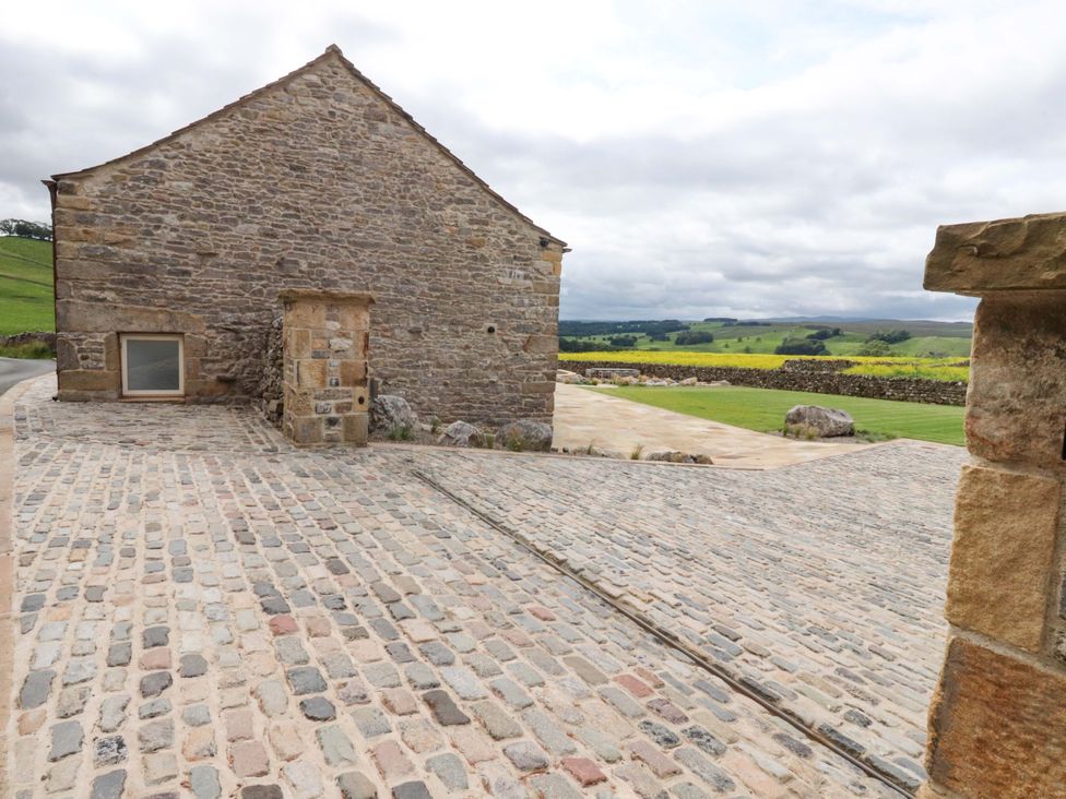An outdoor area with a stone building and cobblestone path at Carden Laithe Barn Threshfield