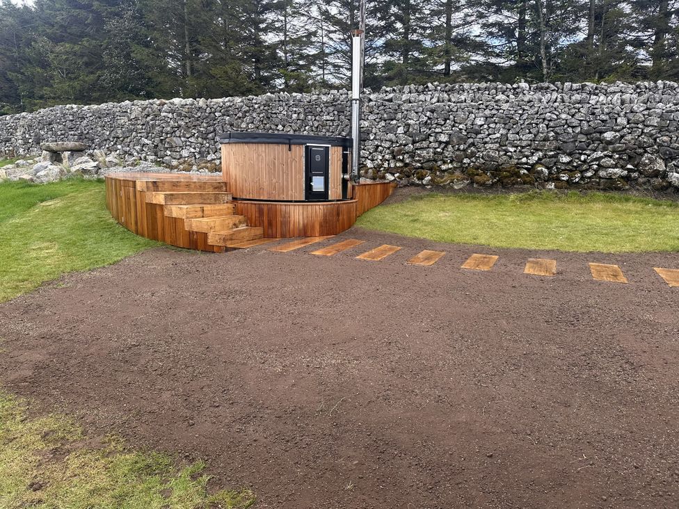 A hot tub with wooden steps and gravel area at Carden Laithe Barn Cracoe
