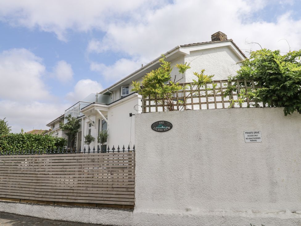 A house with a sign and fence at 1 Island View in Thurlestone