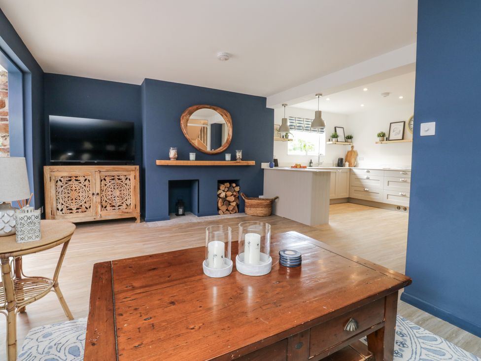 A living room with a television and a coffee table at 1 Island View Thurlestone