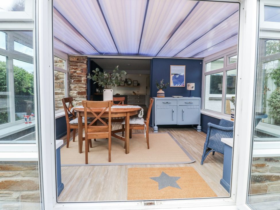 A dining area with a table and chairs at 1 Island View in Thurlestone