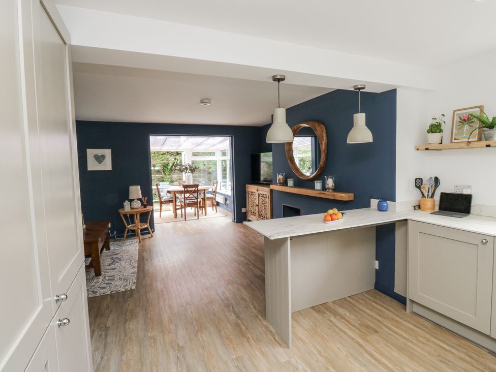 A kitchen with a dining area and television at 1 Island View in Thurlestone