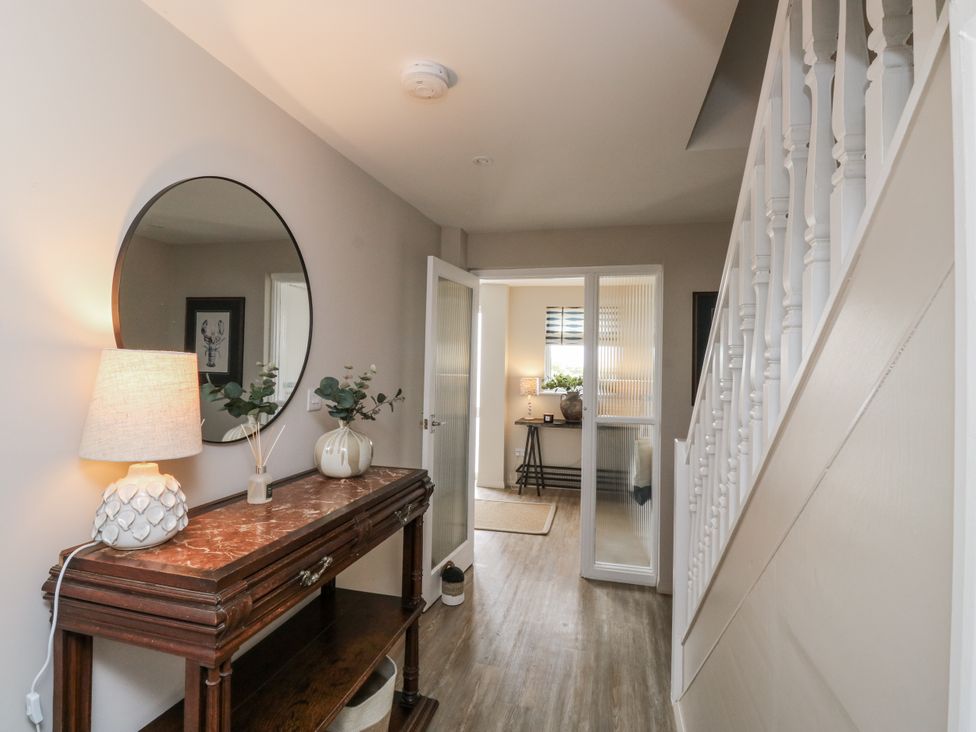 A hallway with a console table and lamp at 1 Island View, Thurlestone