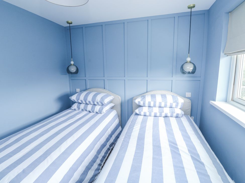 A bedroom with twin beds and a window at 1 Island View in Thurlestone