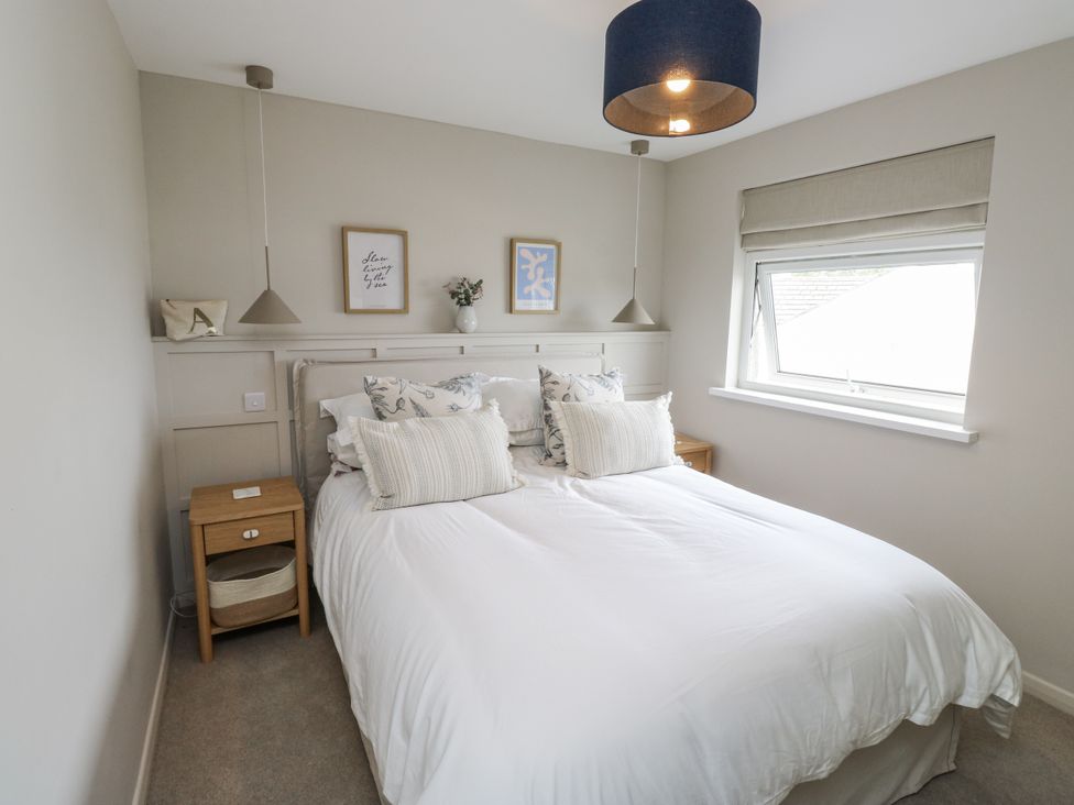 A bedroom with a bed and nightstand at 1 Island View Thurlestone
