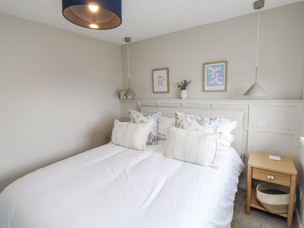 A bedroom with a bed and nightstand at 1 Island View in Thurlestone