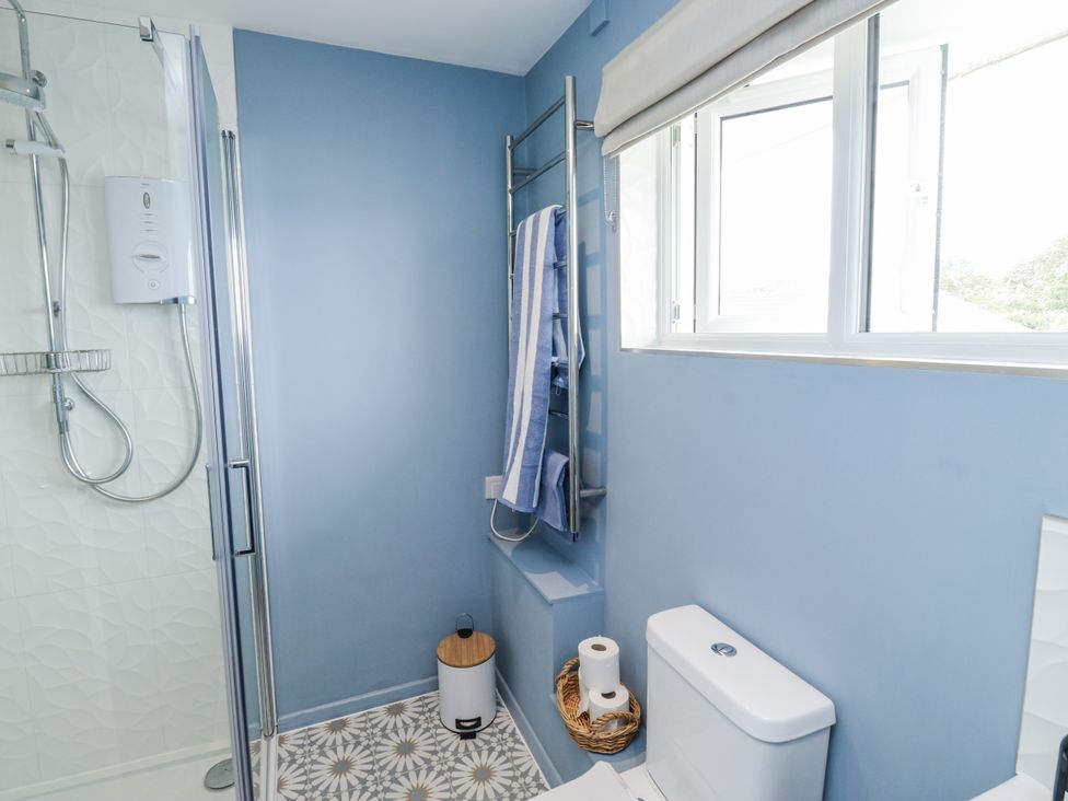 A bathroom with a shower and a toilet at 1 Island View Thurlestone