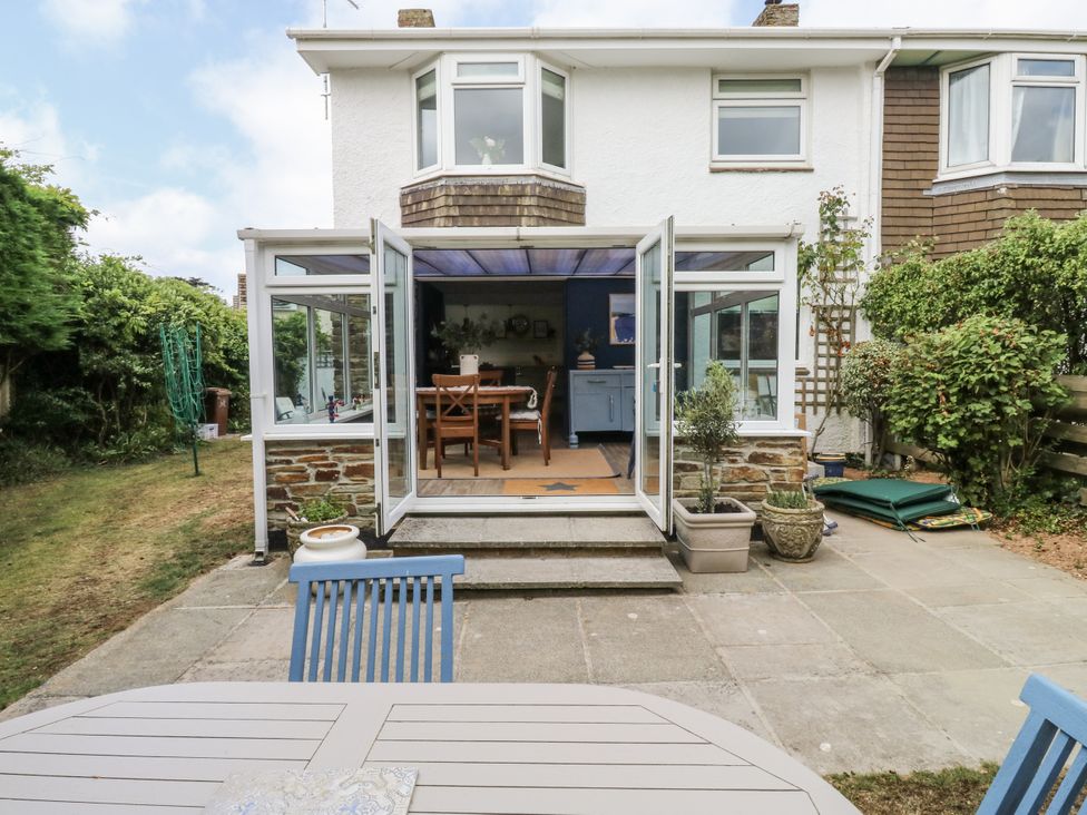 A garden with a house and patio furniture at 1 Island View Thurlestone