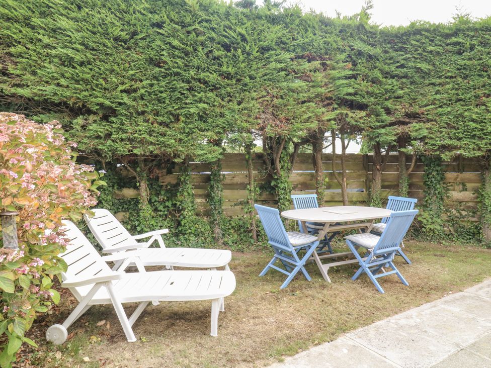A garden with lounge chairs and a dining table at 1 Island View Thurlestone