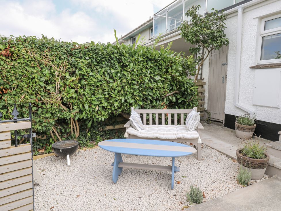 A garden with a bench and coffee table at 1 Island View Thurlestone
