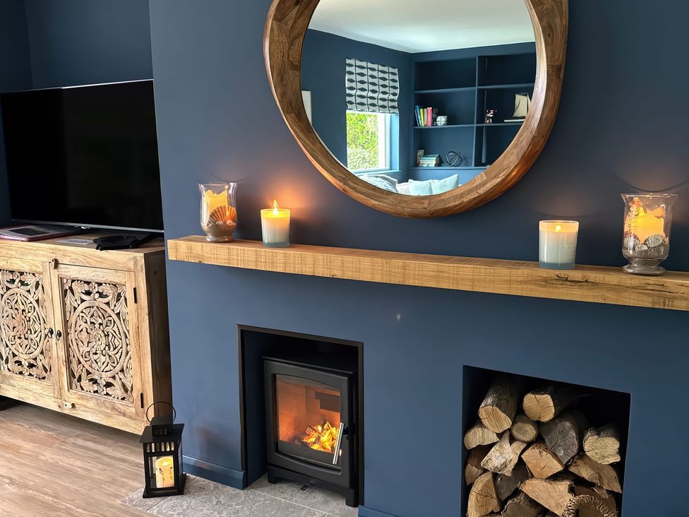 A living room with a fireplace and television at Thurlestone, 1 Island View in Thurlestone