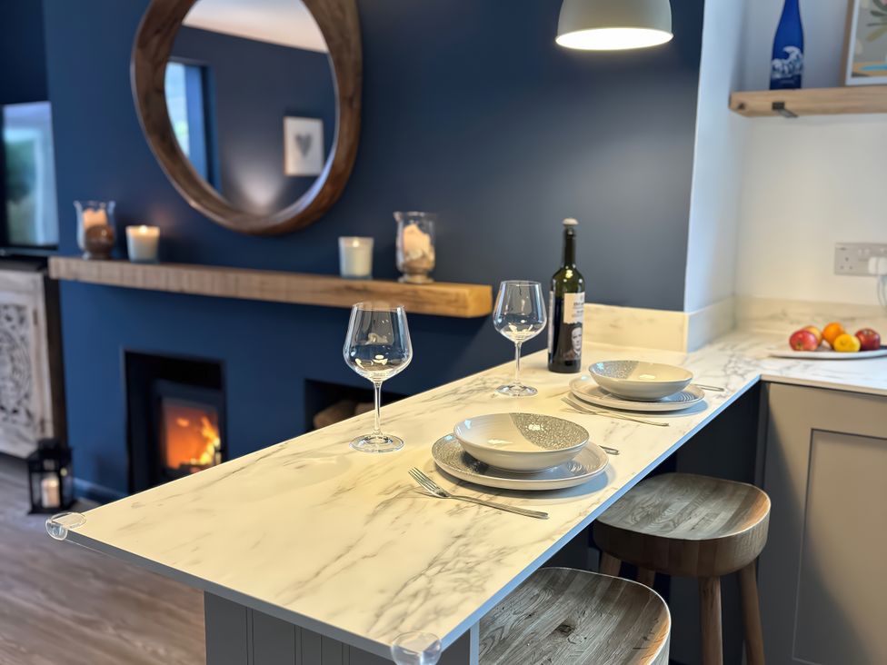 A kitchen with a marble counter and wine bottle at Thurlestone, 1 Island View, Thurlestone