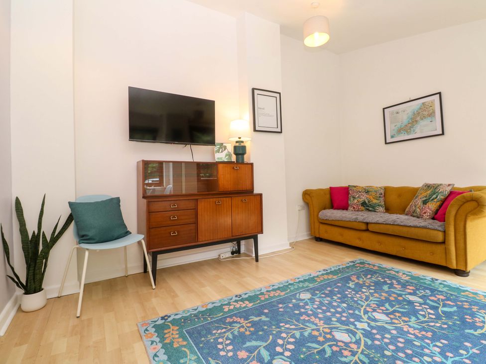 A living room with a sofa and television at The Cow Shed in 