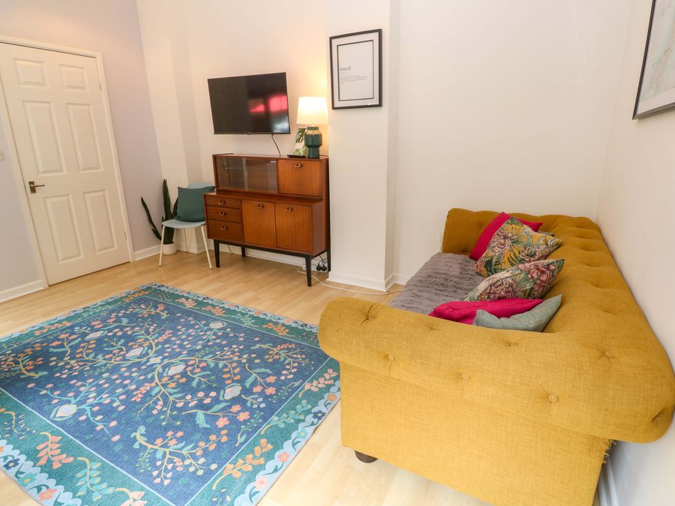 A living room with a sofa and television at The Cow Shed