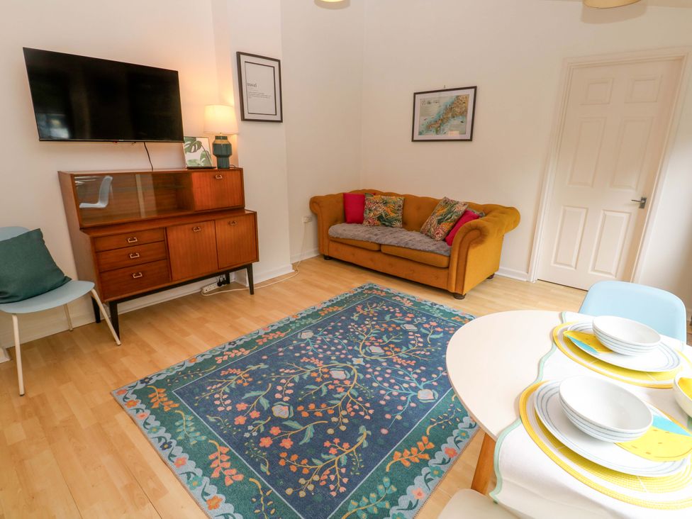 A living room with a sofa and television at The Cow Shed 