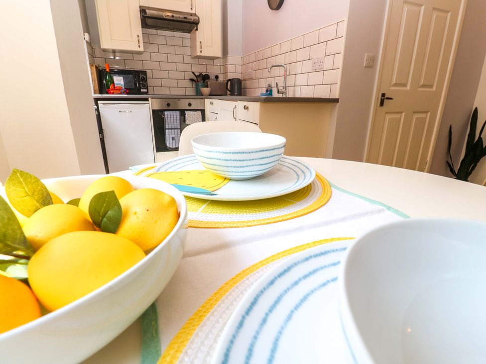 A kitchen with plates and bowls on a table at The Cow Shed in 