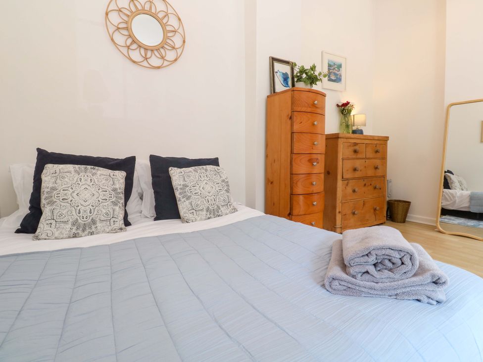 A bedroom with a bed, drawers and a mirror at The Cow Shed