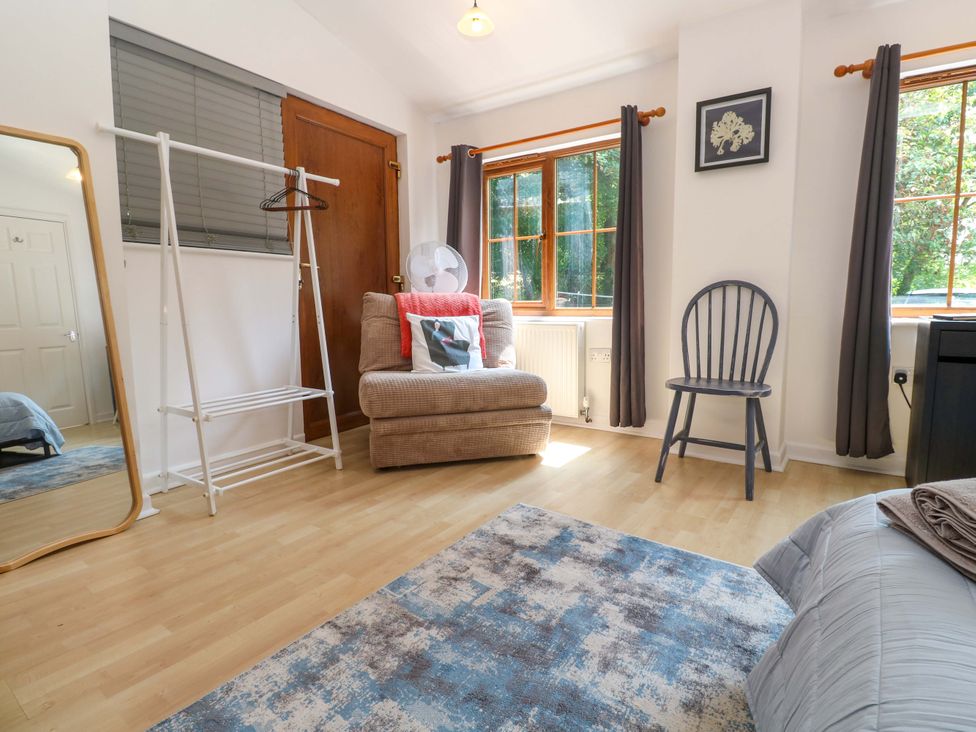 A bedroom with a mirror and a chair at The Cow Shed in 