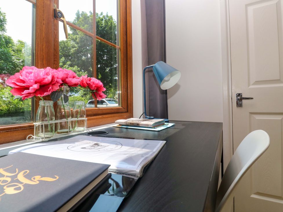 A workspace with flowers on a desk at The Cow Shed in 