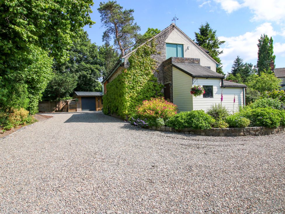 A house with a gravel driveway and garden at The Hideaway in Longden