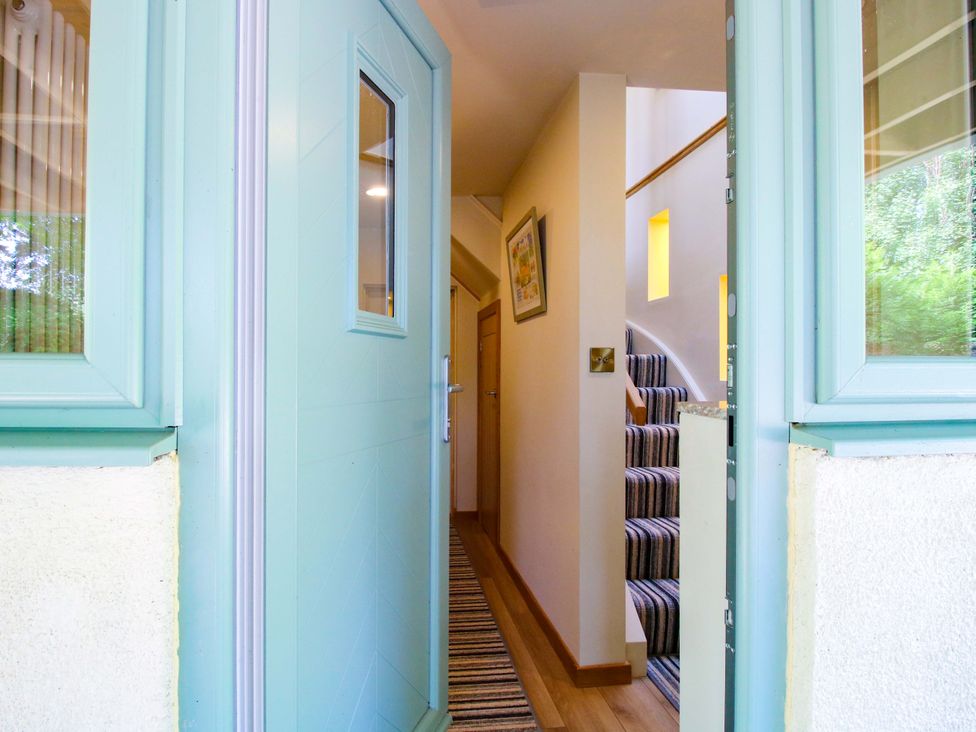 A hallway with a staircase and door at The Hideaway in Longden