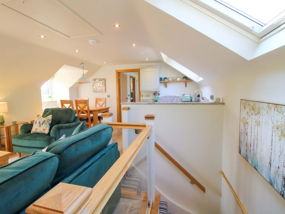 A living room with a sofa and dining table at The Hideaway Longden