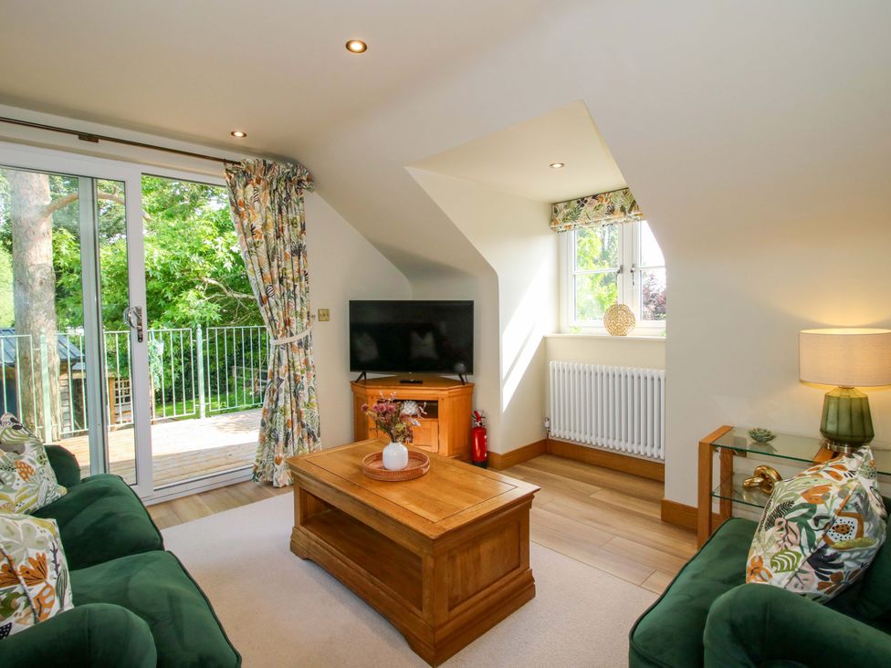 A living room with a sofa and television at The Hideaway in Longden