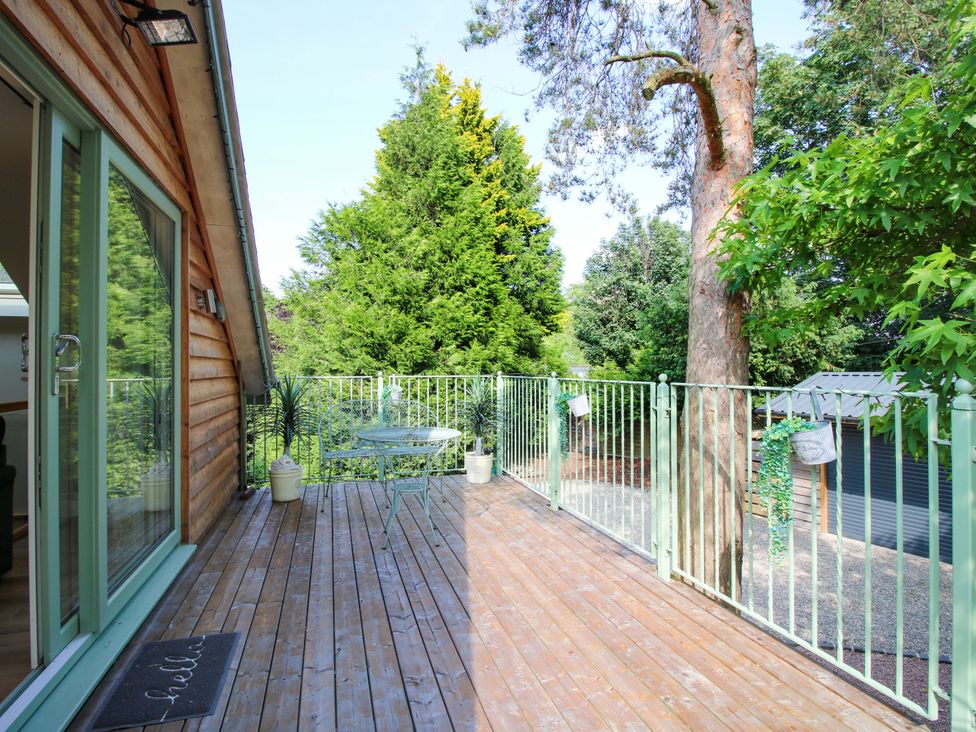 A deck with a table and chairs at The Hideaway in Longden