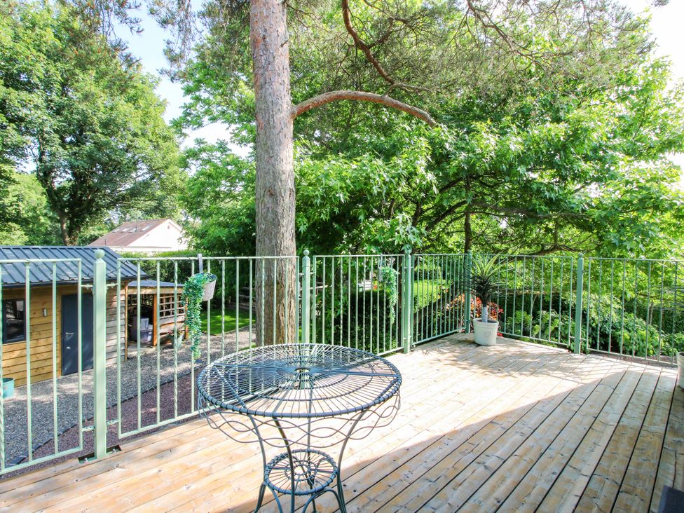 An outdoor patio with a table and plants at The Hideaway in Longden