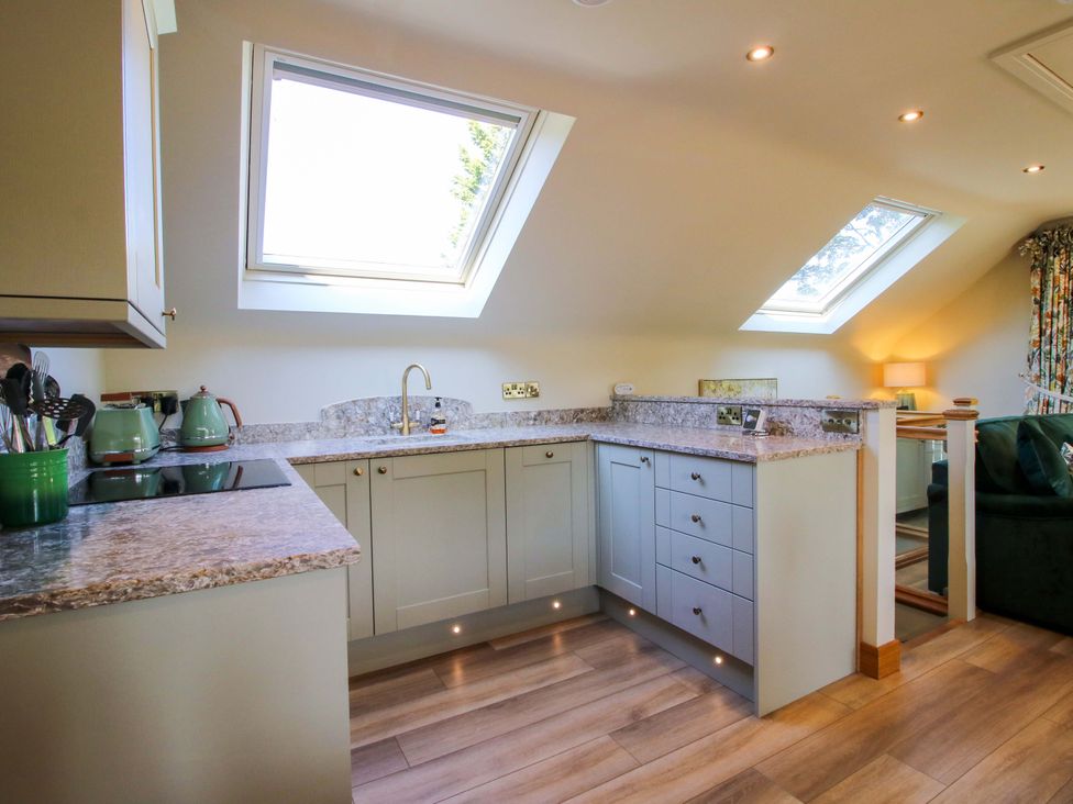 A kitchen with cabinets and a countertop at The Hideaway in Longden