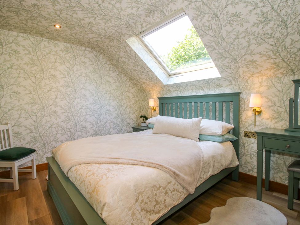 A bedroom with a bed and a skylight at The Hideaway in Longden