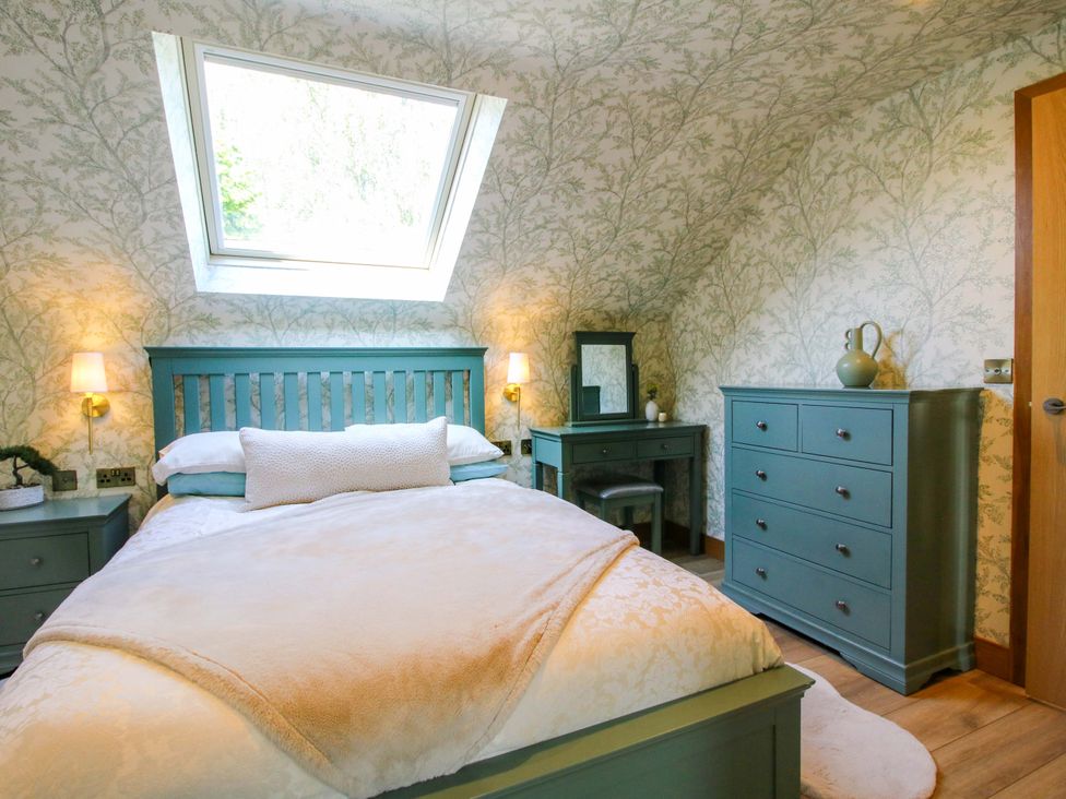 A bedroom with a bed and dresser at The Hideaway in Longden