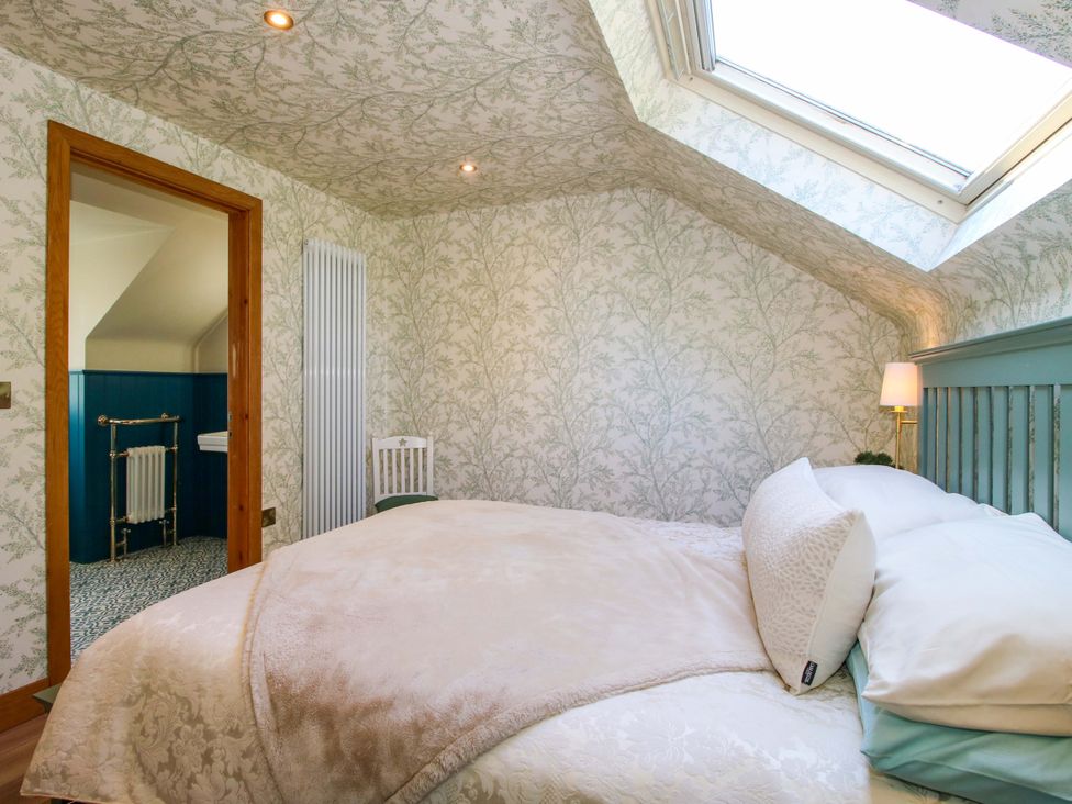 A bedroom with a bed and a window at The Hideaway Longden